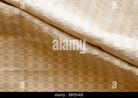 Beige fabric background with geometric checkered pattern with two folds in the middle, textile texture for interior or design Stock Photo