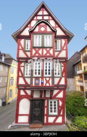 Front facade of an old, renovated and crooked half-timbered house with entrance, red-painted beams and whitewashed compartments, Wetzlar, Germany, Eur Stock Photo