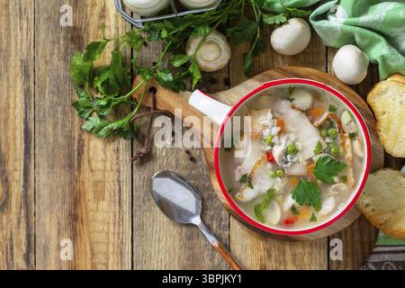 Traditional rustic thick german pea soup with smoked bacon, mushrooms and cereals on wooden table. Hot dinner or lunch. Top view flat lay. Copy space Stock Photo