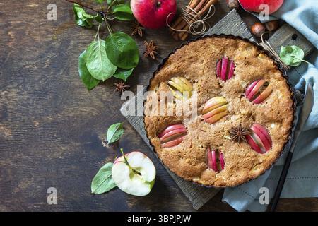 Apple baking gluten free seasonal. Autumn pie with apples, hazelnut and cinnamon on a wooden table. Top view flat lay background. Copy space Stock Photo
