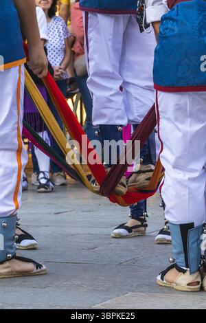 Folk dancers wearing traditional costumes and espadrilles, performing a dance with colorful ribbons Stock Photo