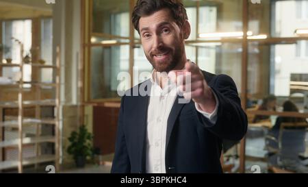 Glad Caucasian man business businessman pointing at camera thumbs up in office smiling entrepreneur executive gesturing you manager guy male showing Stock Photo