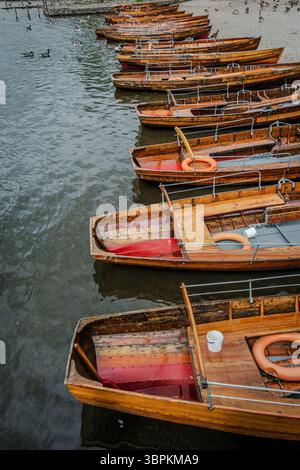 A vertical view of wooden rowboats resting along the shore of Derwentwater, their weathered hulls reflecting the tranquil charm of the Lake District. Stock Photo