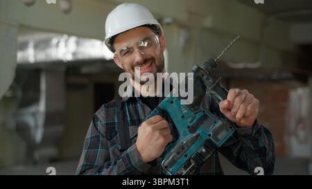 Man building industry repairman builder holding hammer drill repair work construction renovation male engineer handyman foreman engineer architect Stock Photo