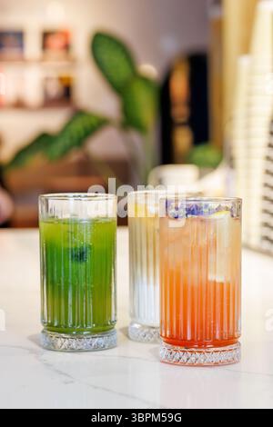 Assorted summer lemonades in glass jars with fresh fruits, ice, and colorful garnishes Stock Photo