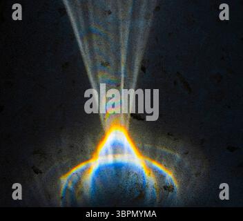 Vibrant rays of light emerge from a prism, scattering into a spectrum of colors against a dark backdrop, showcasing a fascinating interplay of light a Stock Photo