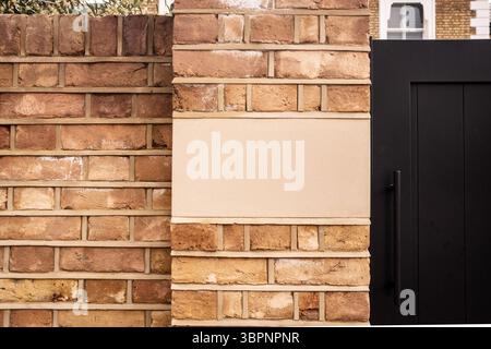 Brick wall with black sign with space for copy on British residential house Stock Photo