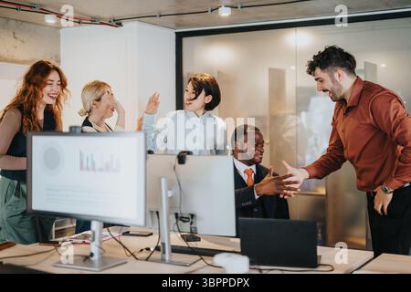 Colleagues Collaborating Enthusiastically in a Contemporary Office Environment Stock Photo