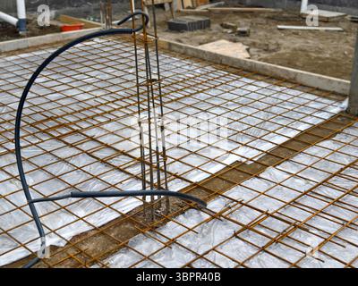 Steel Reinforcement Grid or rebar Installed Over Plastic Sheeting Before Concrete Pour at building construction site Stock Photo