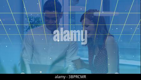 Collaborating colleagues using laptop with digital grid and data points overlay Stock Photo