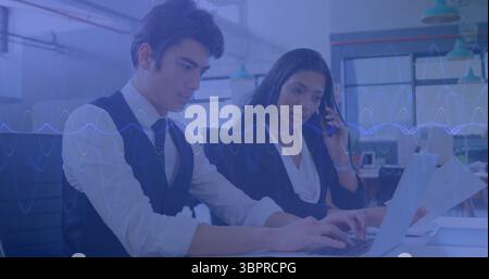 Typing professionals in suits working at desk in office, with laptop smartphone printed documents Stock Photo