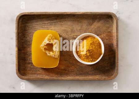 Turmeric soap bar on marble white background. Organic skincare product and bath accessories. View from above. Stock Photo