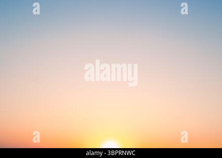 The sunset sky gradient transitions from deep orange to soft blue, capturing a moment of natural beauty. Stock Photo