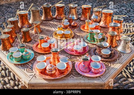 Beautiful copper cezve and cups coffee sets displayed on a table Stock Photo