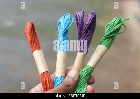 Colorful jute rope threads for crafts held in the hand on outdoor natural light Stock Photo