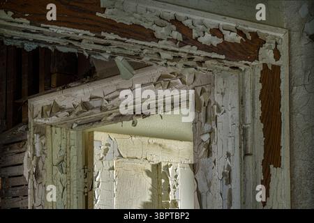 The molding of two doorways with peeling paint in abandoned home, Indiana, USA Stock Photo