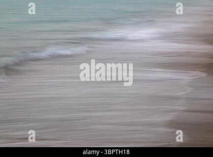 In camera motion blur, waves along the beach, white waves sea green ocean, abstract vertical Stock Photo