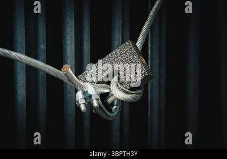 A closed lock hangs on the wire of the grate Stock Photo