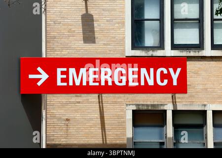 A red sign with the word "Emergency" at a hospital. Stock Photo