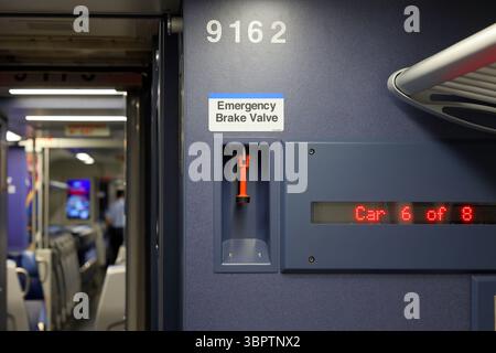 Emergency Brake Valve and signage in an American passenger railroad train car. Stock Photo