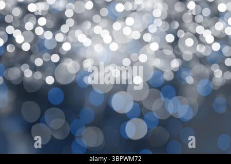 White silver blue light circles are floating across dark field in flat design bokeh composition Stock Photo