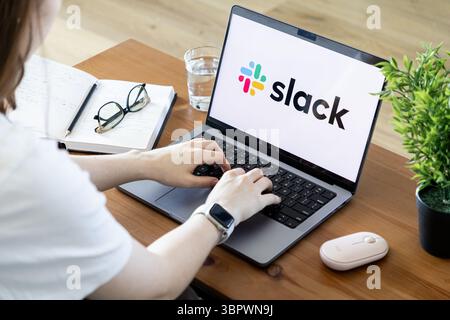 Poznan, Poland - June 15, 2025: Slack application interface displayed on a laptop, with a person typing for effective digital communication and seamle Stock Photo