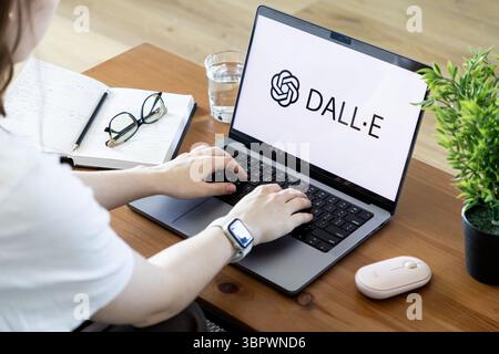 Poznan, Poland - June 15, 2025: DALLE application visible on laptop screen with hands typing, emphasizing artificial intelligence for image generation Stock Photo