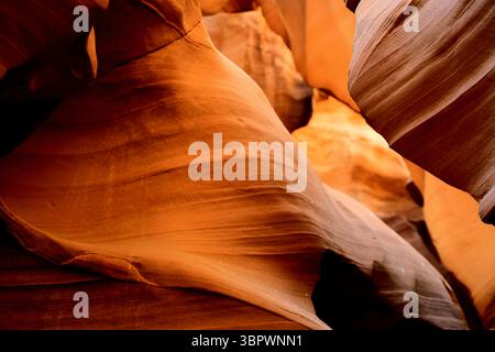 Golden orange and red sandstone waves flow through Antelope Canyon’s narrow passage, sculpted over eons by wind and water’s relentless erosion calmly. Stock Photo