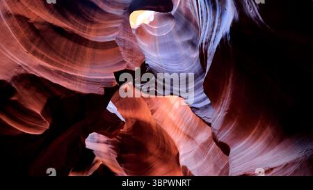Light floods Antelope Canyon’s twisting sandstone corridors in Page Arizona, highlighting ancient red and orange rock shaped by wind and water ever!!! Stock Photo