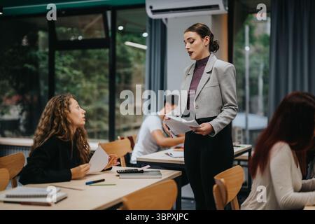 Teacher engaging with attentive students in a modern classroom setting Stock Photo