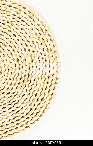 Top view of brown wicker table mat on white background. Straw round tray, flat lay, copy space. Stock Photo