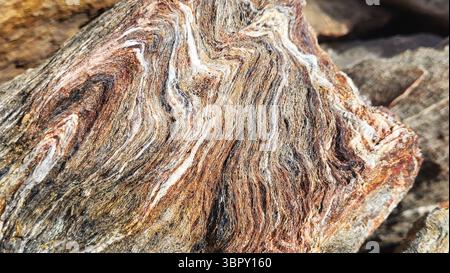 Close-up of a unique multi-layered stone chunk with natural wave-like color structures Stock Photo
