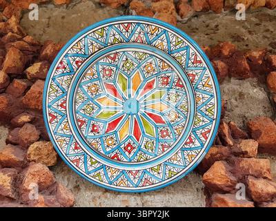 Beautiful hand-painted traditional ceramic plate from Spain on a stone wall Stock Photo