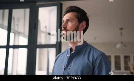 Thoughtful Caucasian man bearded guy middle-aged dad pondering at home. Pensive parent contemplating adult male father thinking with serious facial Stock Photo