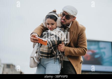 Young couple making playful faces while taking a selfie outdoors Stock Photo