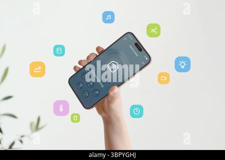 Smart home interface featuring multiple home automation functions visualized through bright graphic elements flying around phone Stock Photo