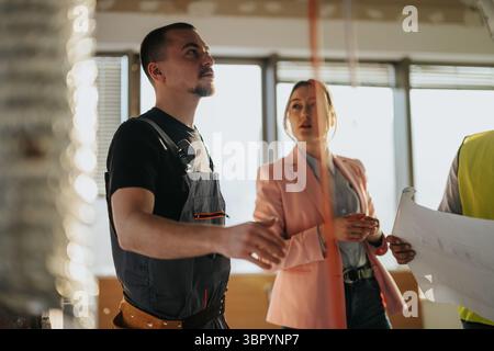 Collaboration Between Construction Professional and Businesswoman at Work site Stock Photo