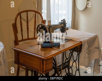 A vintage treadle sewing machine in the recreated early 20th-century apartment at Casa Milà (La Pedrera) by Antoni Gaudí in Barcelona, Spain. Stock Photo