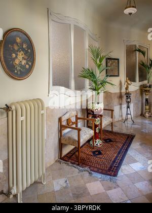 An elegant hallway with period furniture and unique windows in the preserved apartment at Casa Milà (La Pedrera), by Gaudí, Barcelona, Spain. Stock Photo