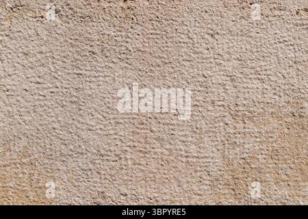Textured beige stone surface with subtle grid pattern. Stock Photo
