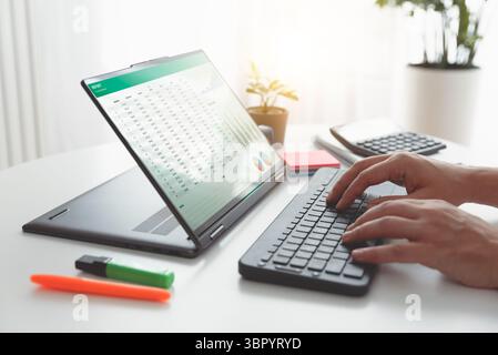 Man using 2 in 1 laptop to financial data analysis. Analyst at work. Stock Photo