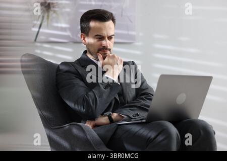 Professional psychologist having online consultation with his client via laptop indoors Stock Photo