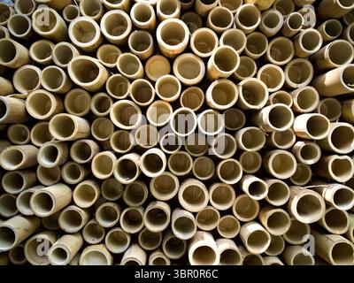 Close-up of natural bamboo slices stacked to a wall, forming a round wooden texture. Stock Photo