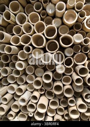 Symmetrical bamboo wall made of cut-up sticks, showing circular wooden patterns. Stock Photo