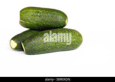 Three fresh, crunchy cucumbers grown in a small garden before processing. White background, isolated. Stock Photo