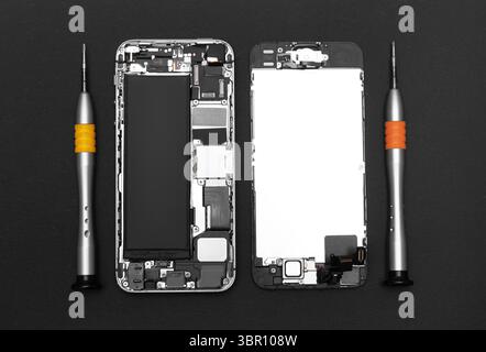 Disassembled mobile phone and repairing tools, close-up Stock Photo
