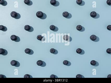 Blueberries forming a repeat pattern on a light blue background. Stock Photo