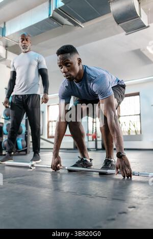 African American men training with barbell at gym on rubber mat with medicine balls. Strength, fitness, training, gymnasium, wellness, motivation, per Stock Photo