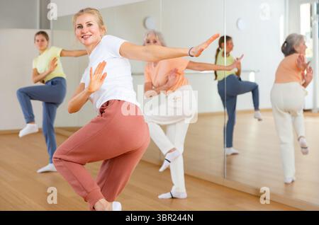 Woman performing aerobic dance during group training Stock Photo