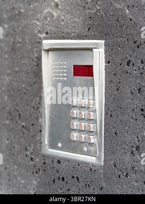 Close-up view of a modern intercom system mounted on the wall of a residential apartment building. Stock Photo